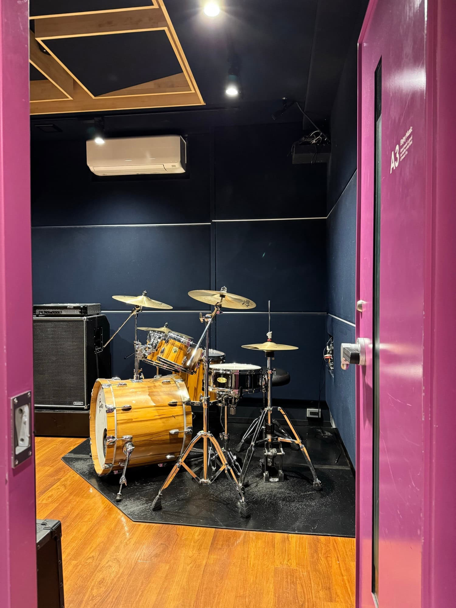 Looking through the door of my drum practice room. The kit looks set up and ready to be played. © 2025 Norbert Woehnl Photography.