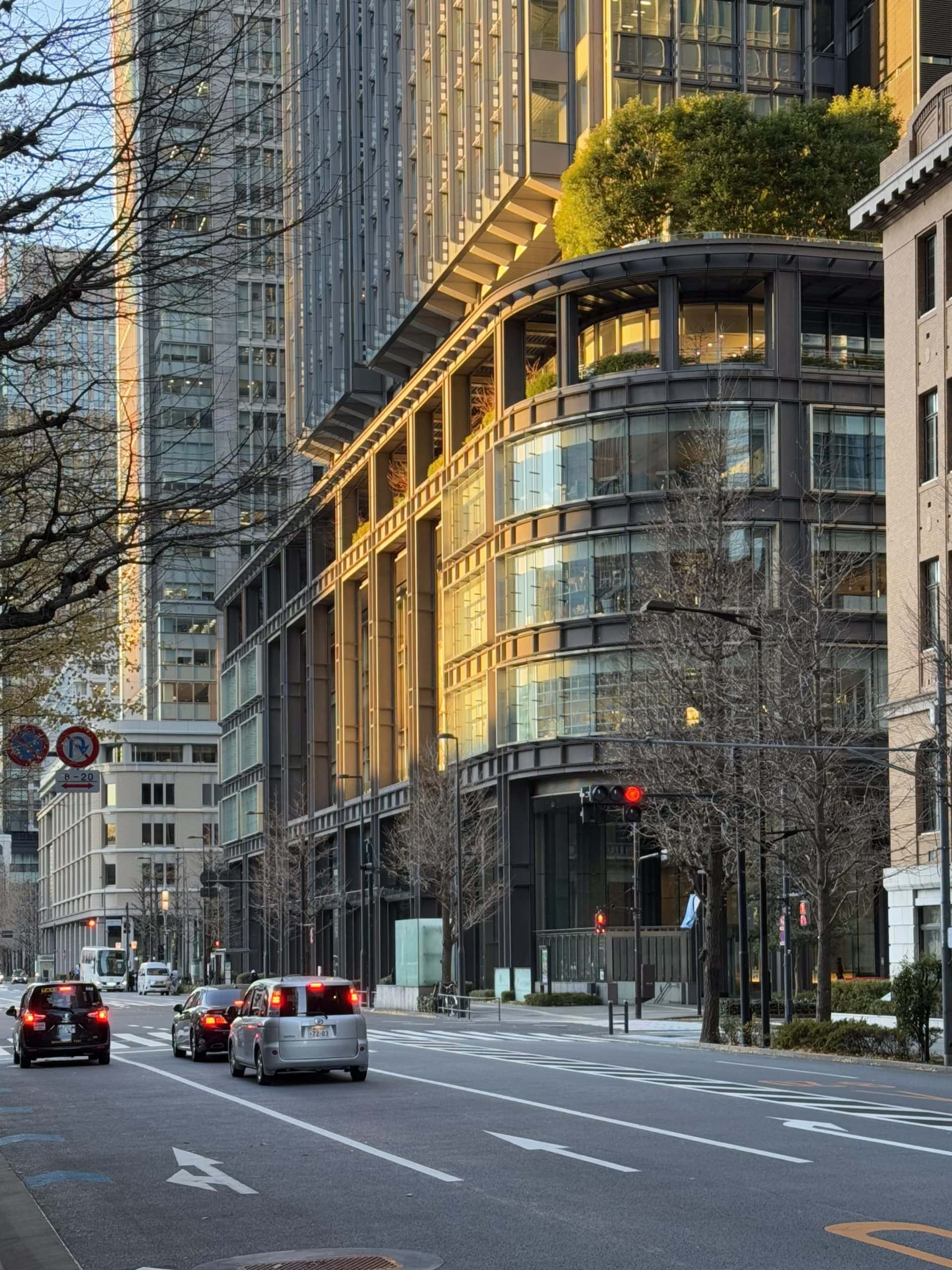 Detail of the morning sun casting a warming light on a distinctively rounded corner of the Shin-Marunouchi Building in Tokyo, Japan. © 2025 Norbert Woehnl Photography.