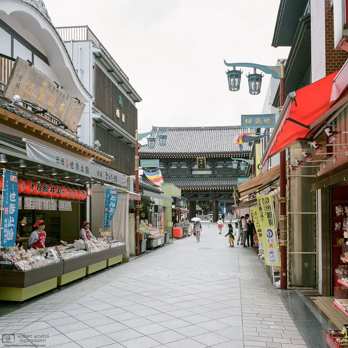 Approaching Kawasaki Daishi (Heiken-ji) Temple in Kawasaki, Japan, along a road lined with shops. © 2018 Norbert Woehnl Photography.