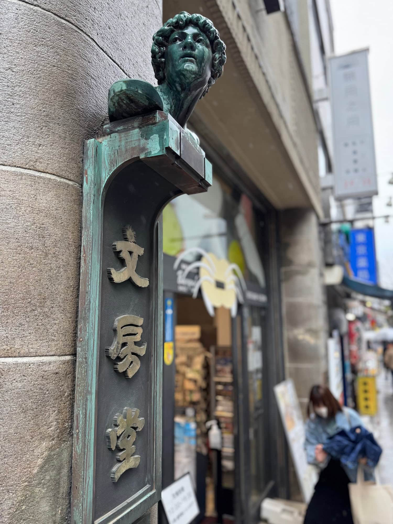 Small sculpture at the entrance of Bunpodo, a stationery and arts supplies store in Jimbocho, Tokyo. © 2025 Norbert Woehnl Photography.