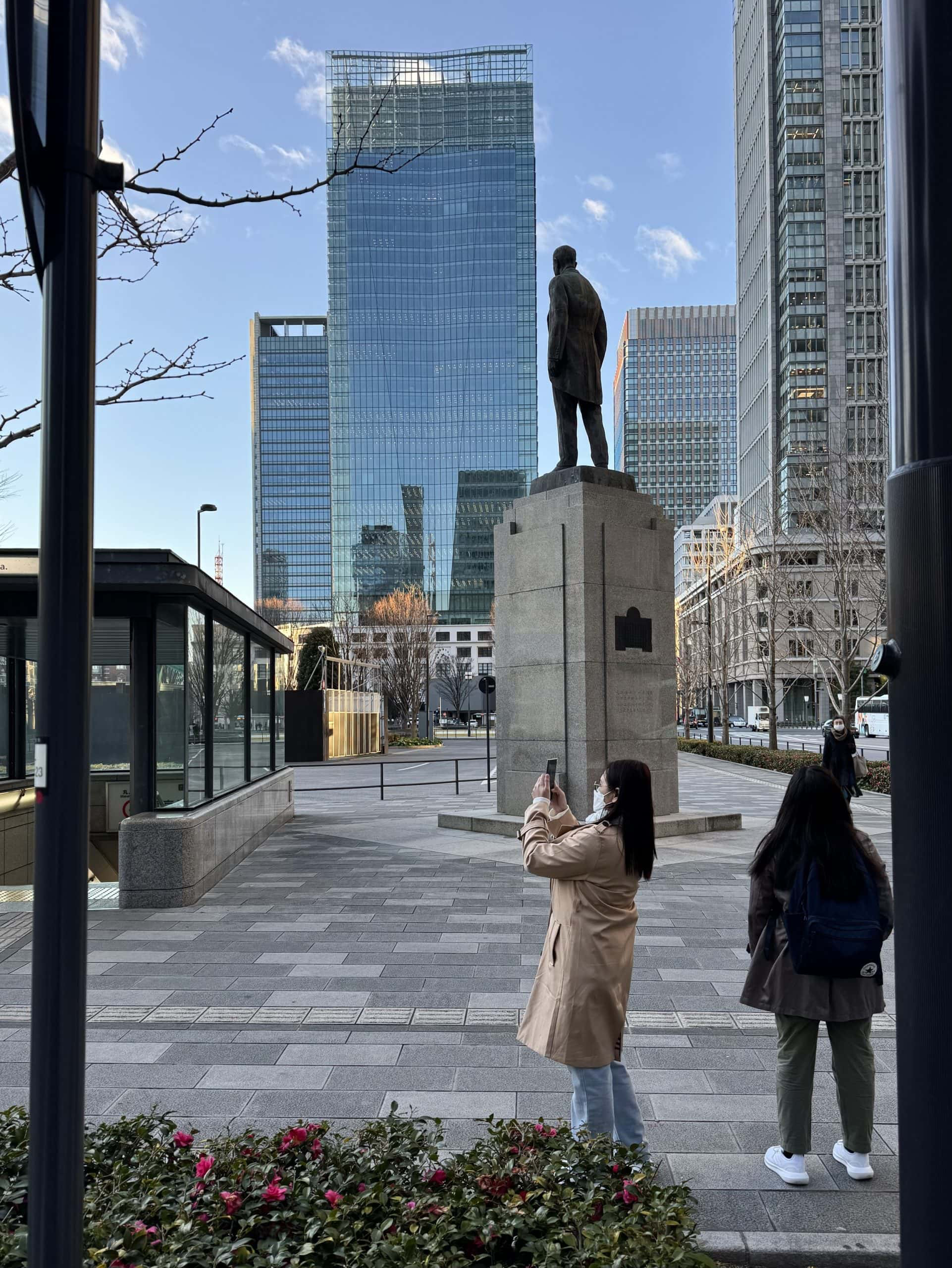 Some early risers are taking photos of Tokyo Station on the wide plaza in front of it. The high-rise building in the center of the photo is JP Tower. © 2025 Norbert Woehnl Photography.