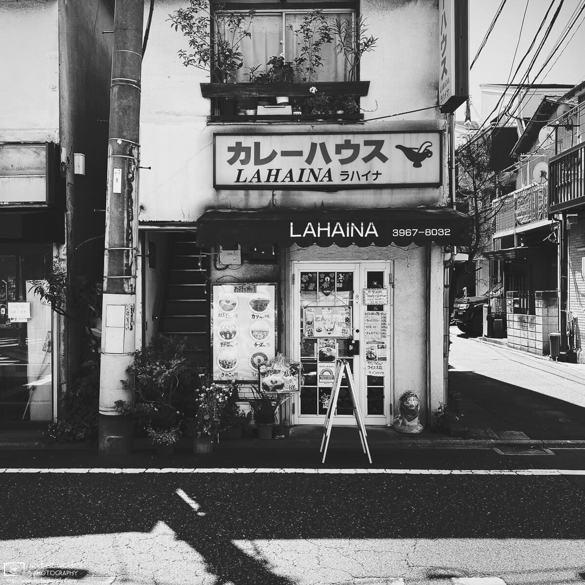 High-contrast monochrome photograph of Curry House Lahaina, a small restaurant in the Azusawa neighborhood of Itabashi Ward in Tokyo, Japan. © 2022 Norbert Woehnl Photography.