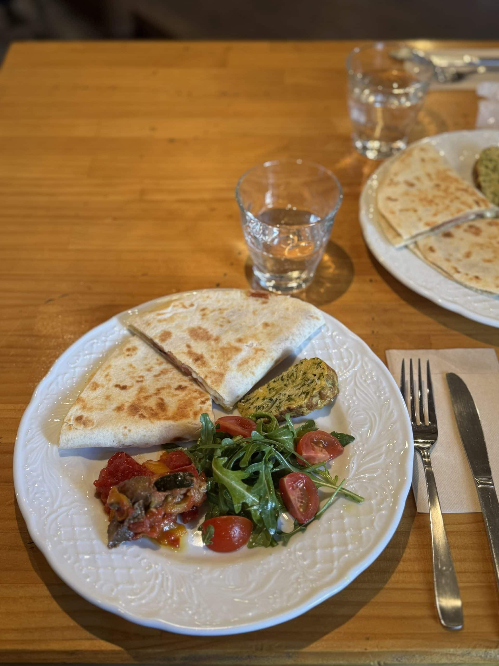Main lunch dish of Piadina (Italian style flatbread filled with ham and cheese), and various sides. © 2025 Norbert Woehnl Photography.